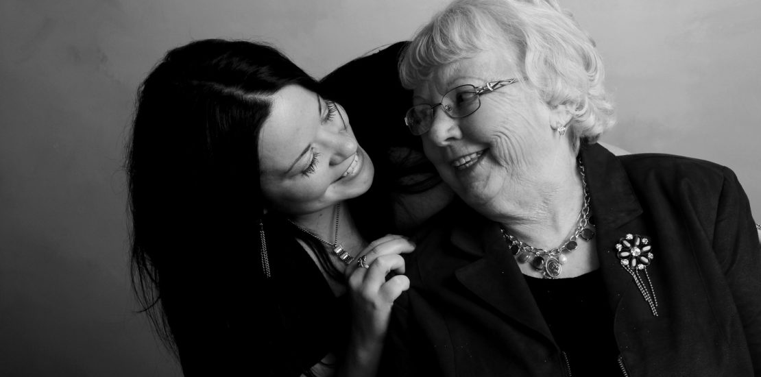 Grandmother and granddaughter smiling at eachother in a photo studio - Tisser Law Group Probate